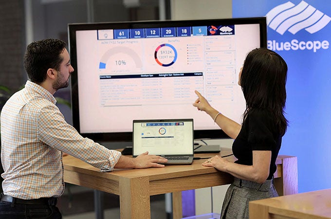 Two BlueScope employees looking at a screen with one employee pointing to it