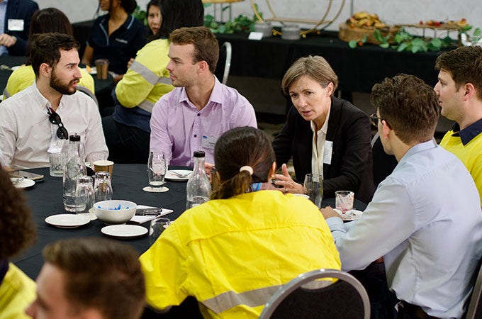 A group of delegates attending a graduate breakfast at a conference room